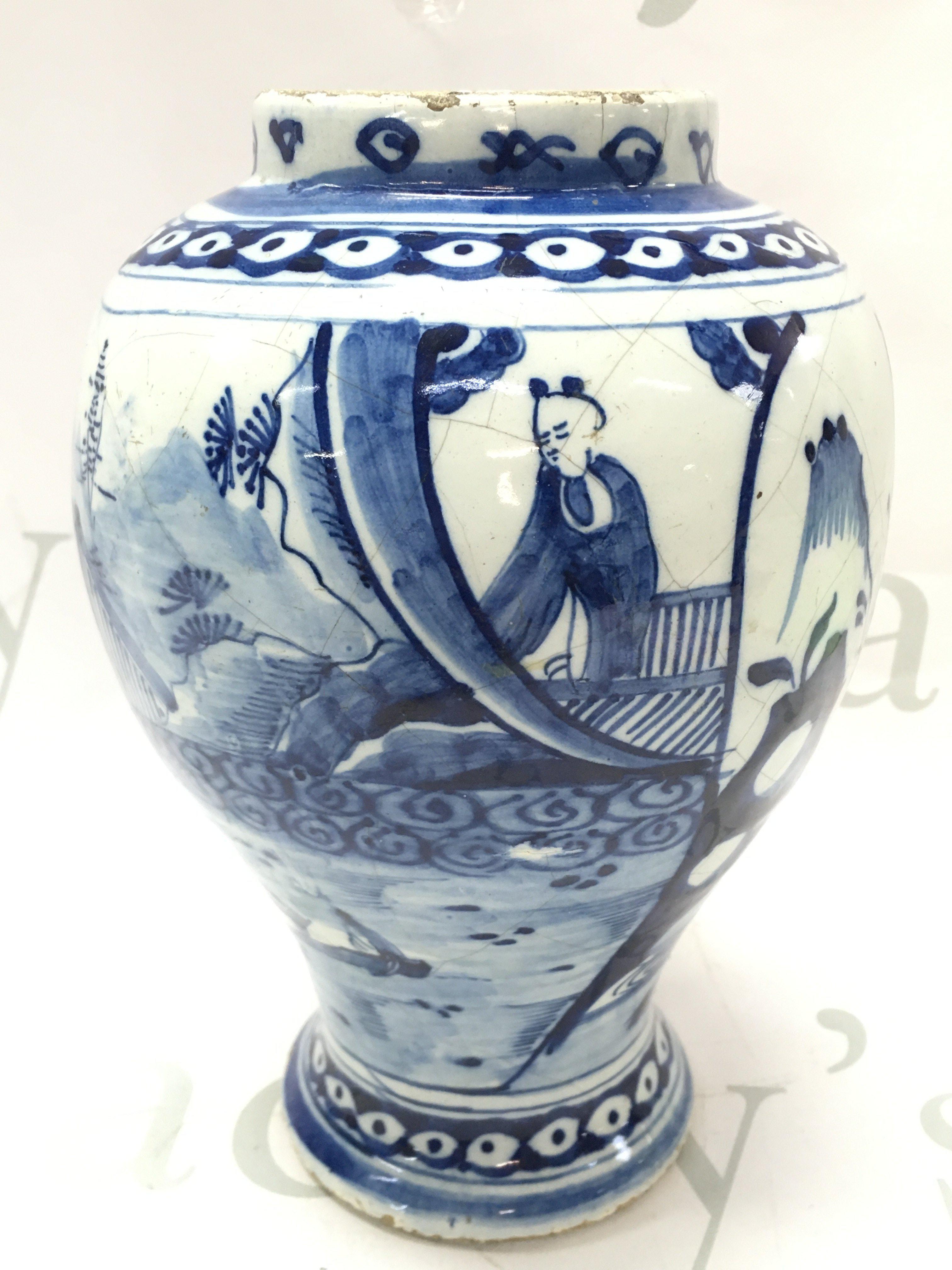 An 18th century Delft Dutch chinoiserie vase with river temple scene decoration , hairline crack damage and chips. 21cm tall approximately. This lot cannot be posted