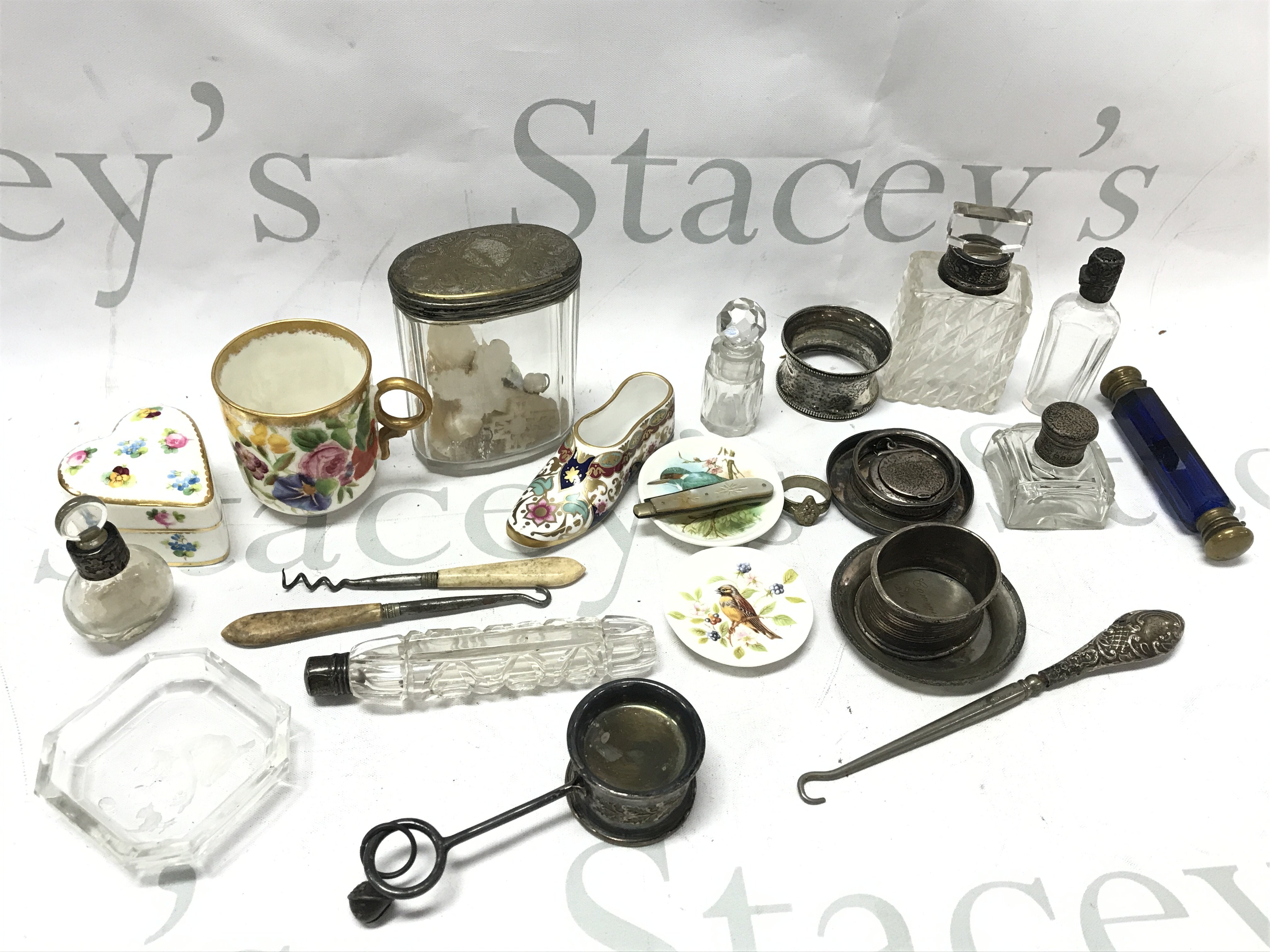 A Collection of oddments including cut glass silver Hallmarked bottles, Mintons ceramic heart trinket box , silver hallmarked walking stick topper, vintage Negretti & Zambra compass ,Spode. This lot cannot be posted