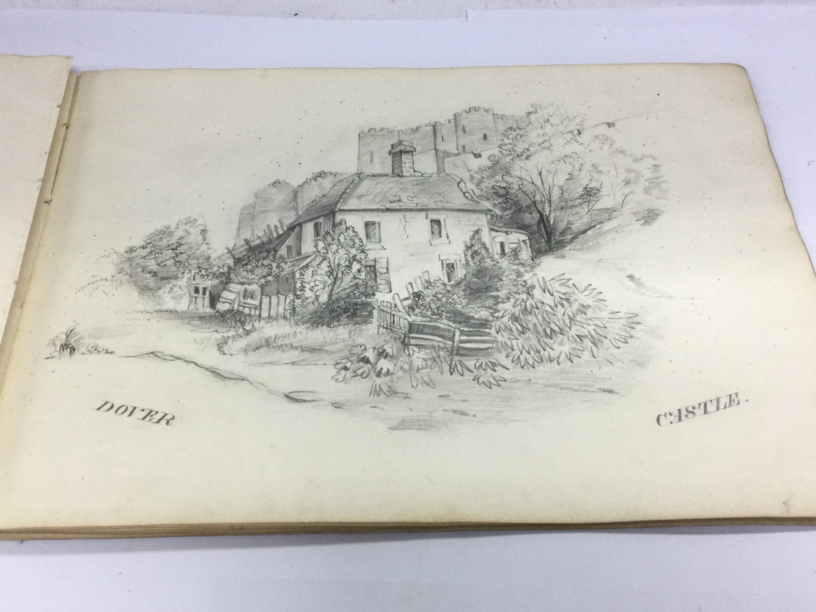 A sketch book containing various pencil drawings and a watercolour. Shipping category A.