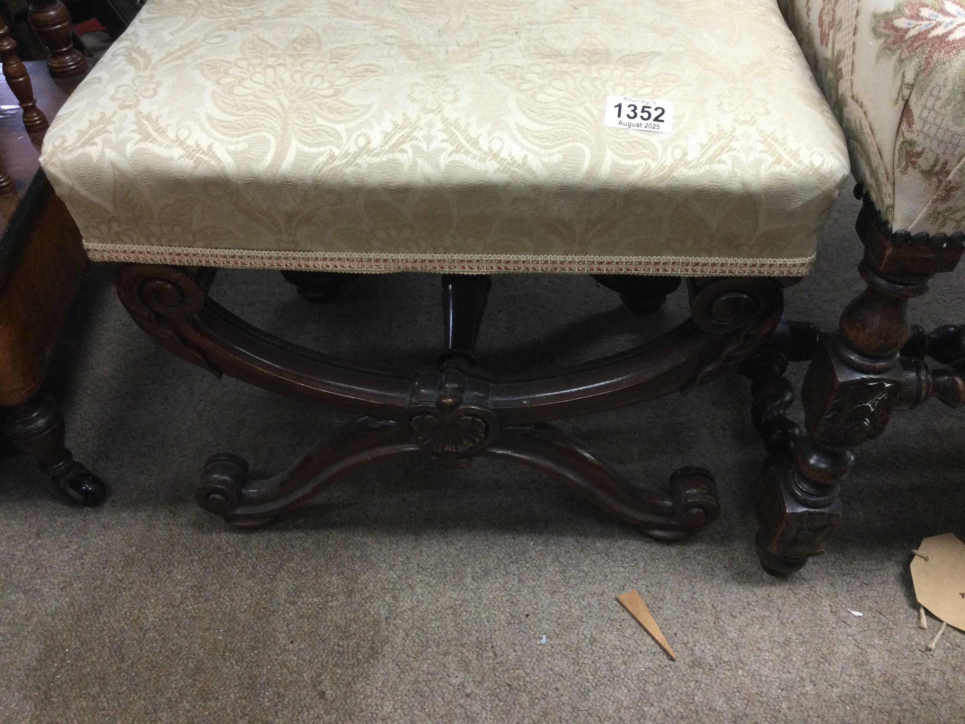 A Victorian mahogany X framed stool on carved legs .