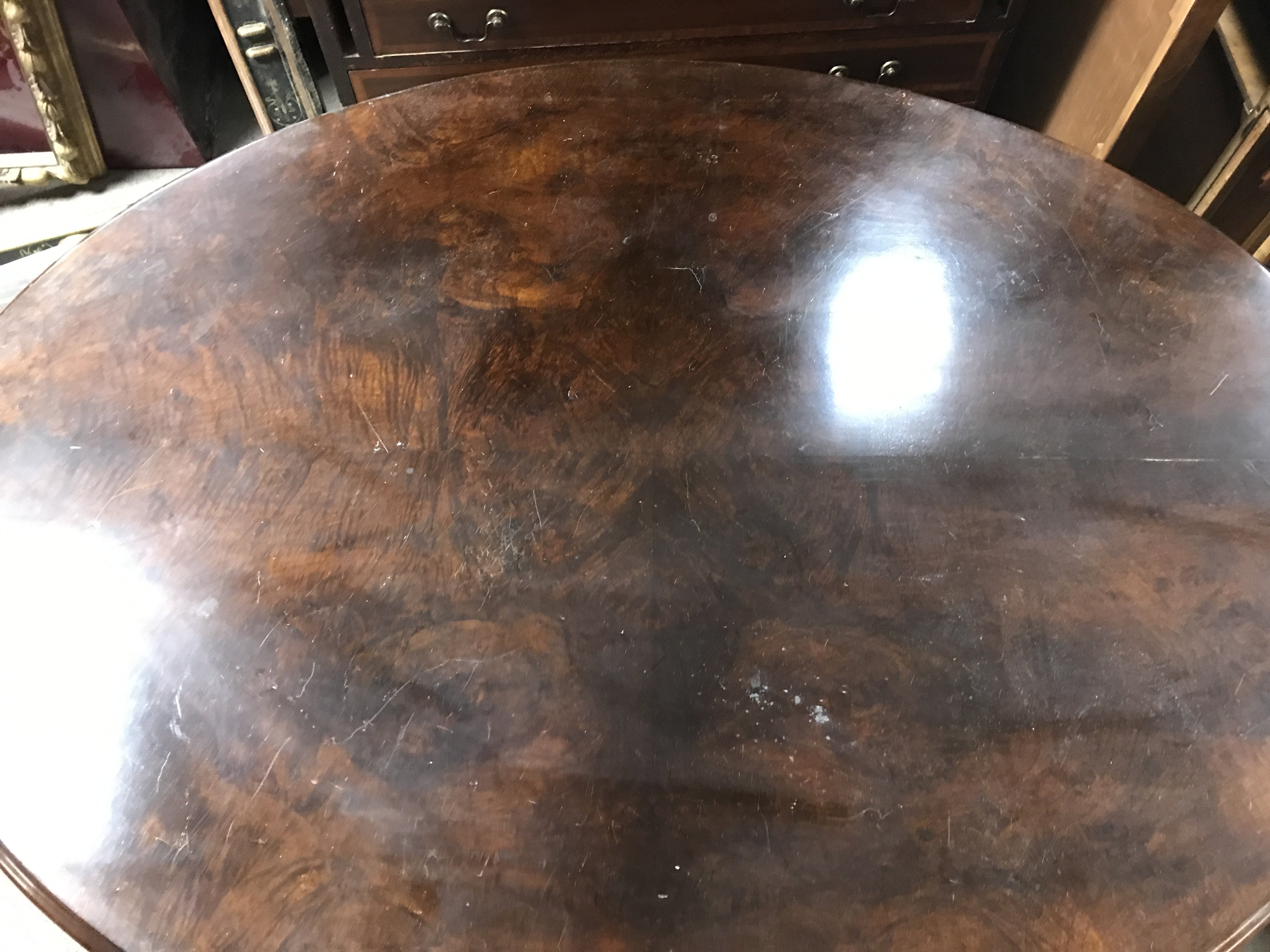 A Victorian walnut tip action table with a circular shape length 102cm x width 132cm x 75cm tall