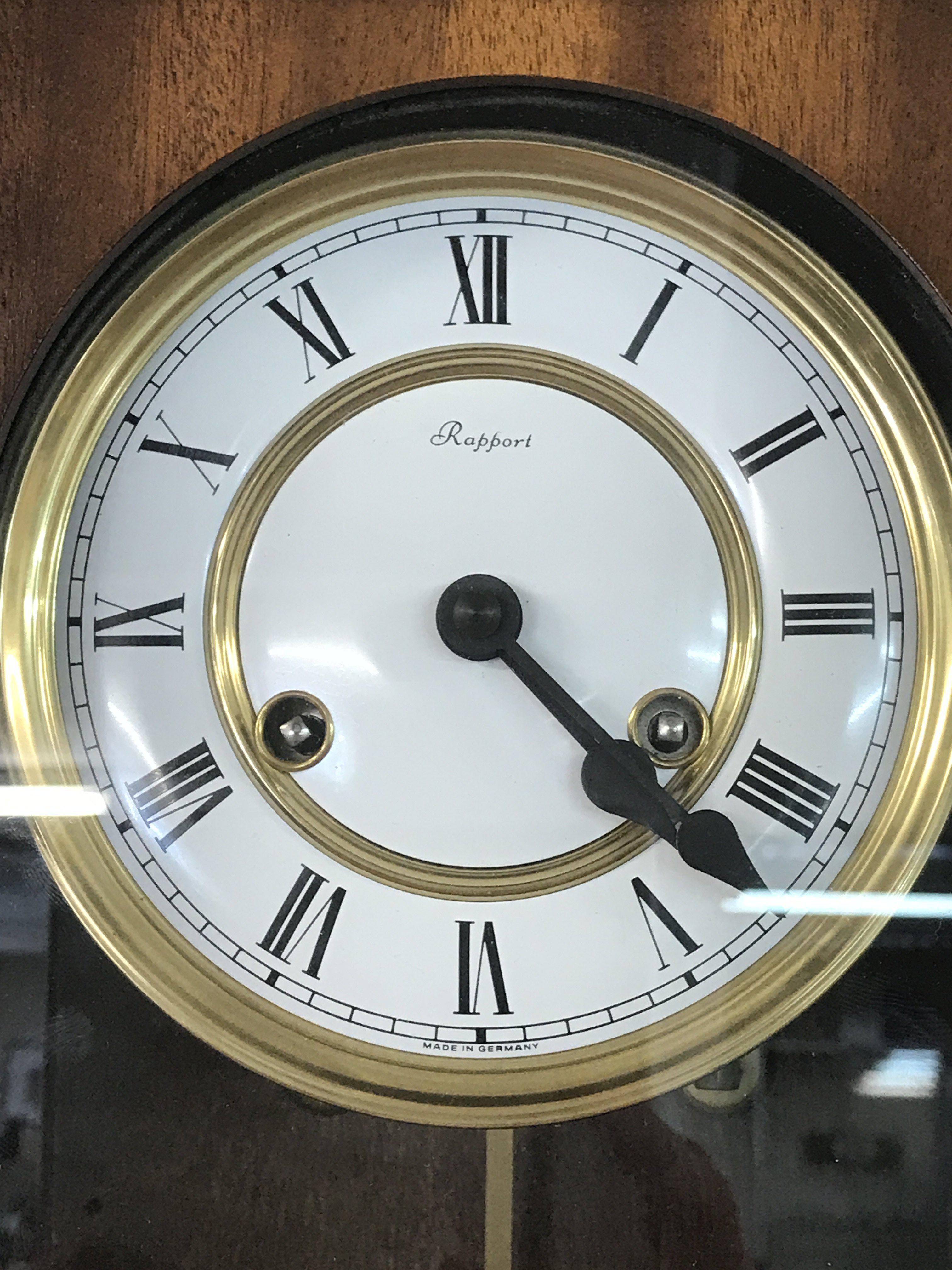 A German Rapport Wall clock with key and pendulum , 23cm tall approximately. This lot cannot be posted- NO RESERVE