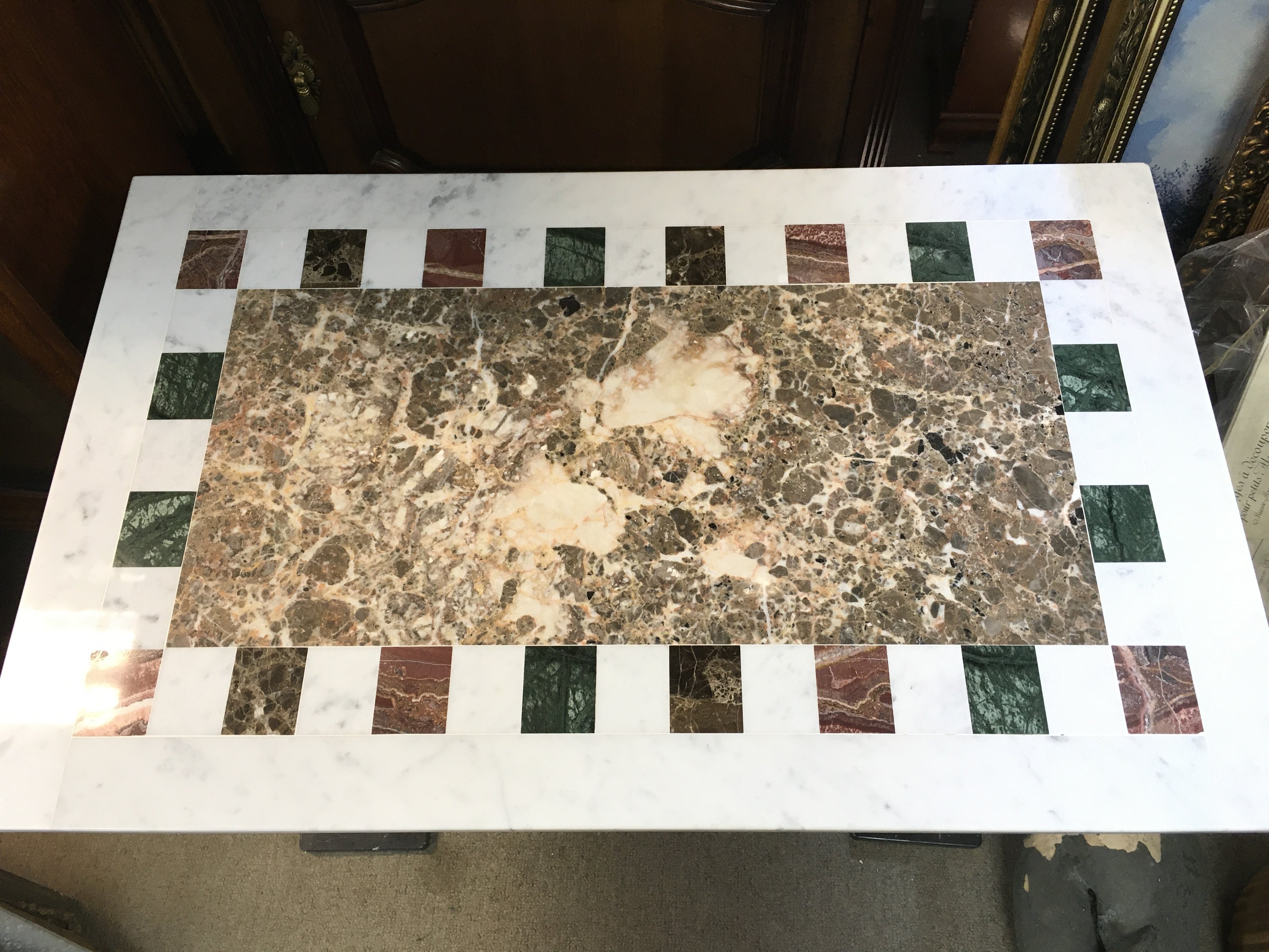 A marble top table with cast iron legs , 90cm wide, 60cm tall.