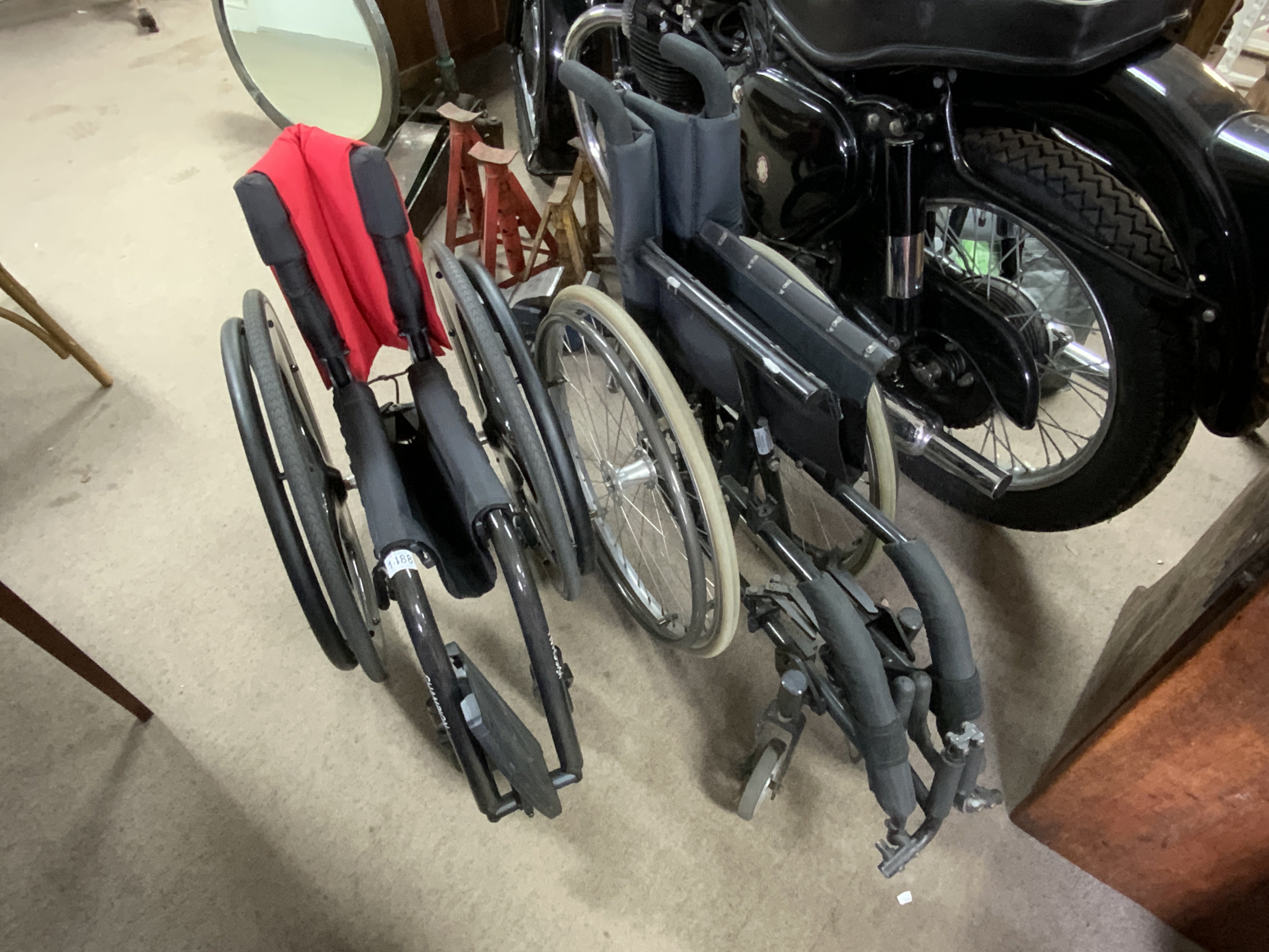 A Carbon Fibre Kuschsall wheelchair together with an additional wheelchair.
