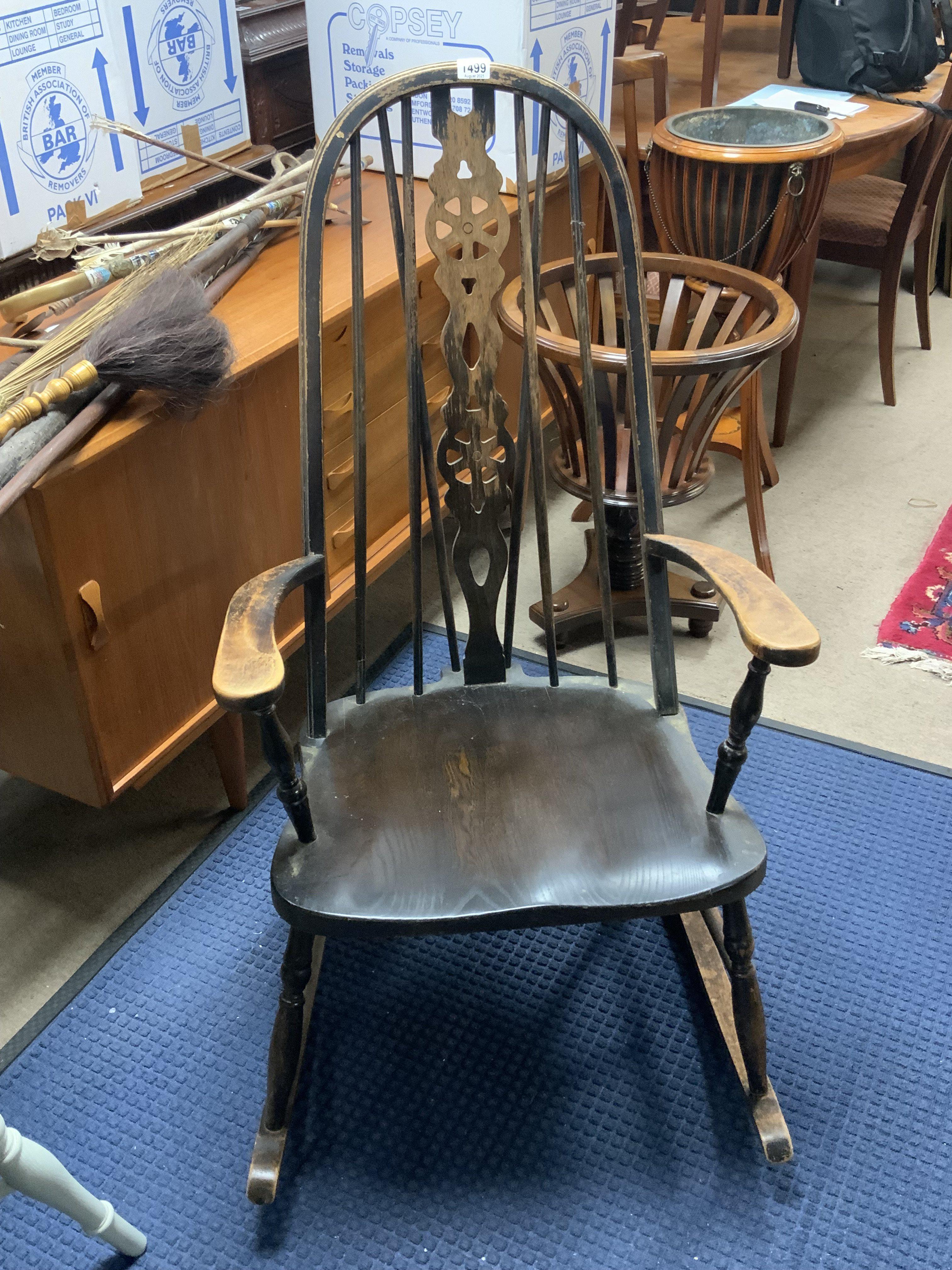 A vintage oak dark stained wheel back rocking chair.
