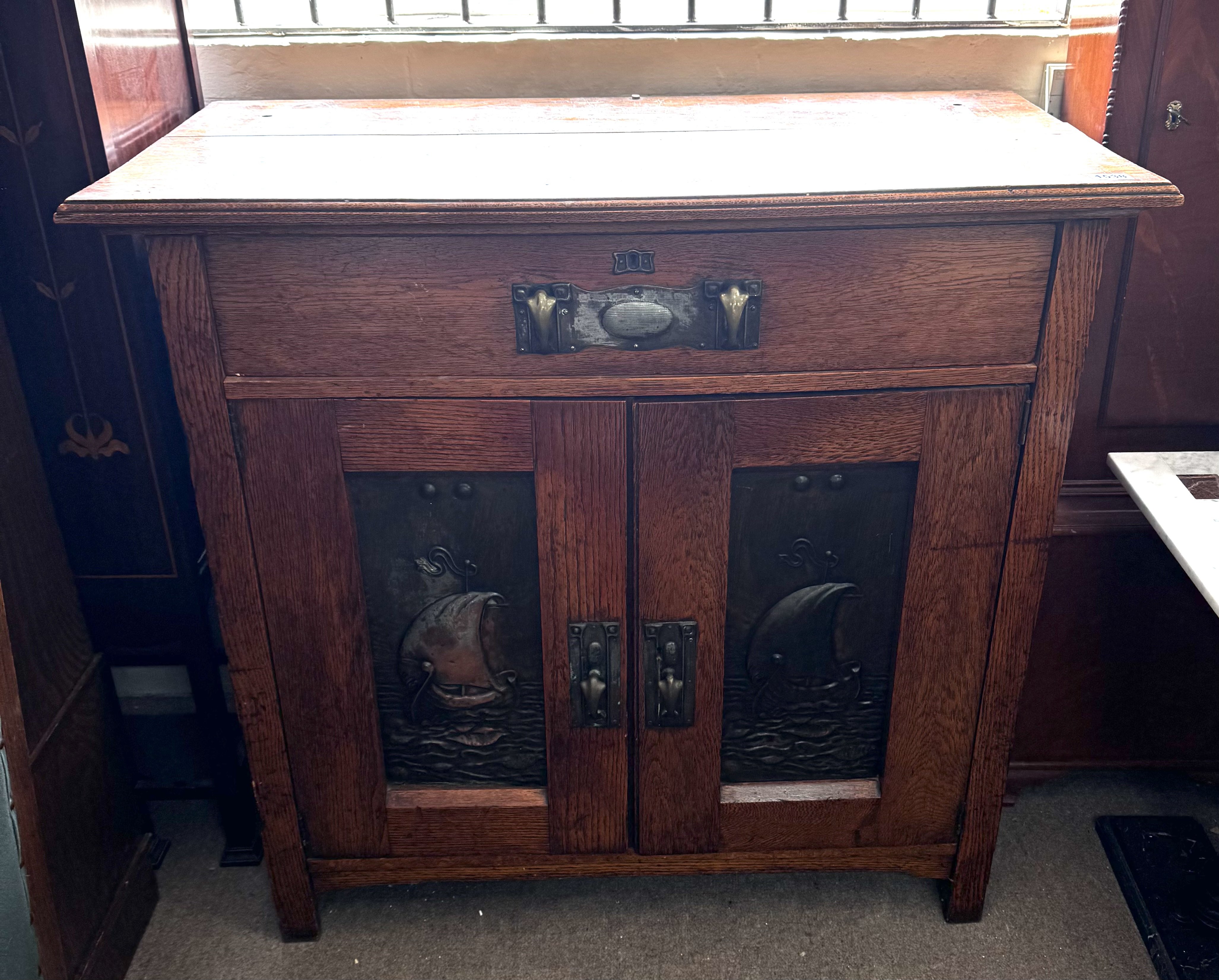 Arts and Crafts oak cabinet made brass fittings and inset pressed panels. 106cm x 102cm x 51cm