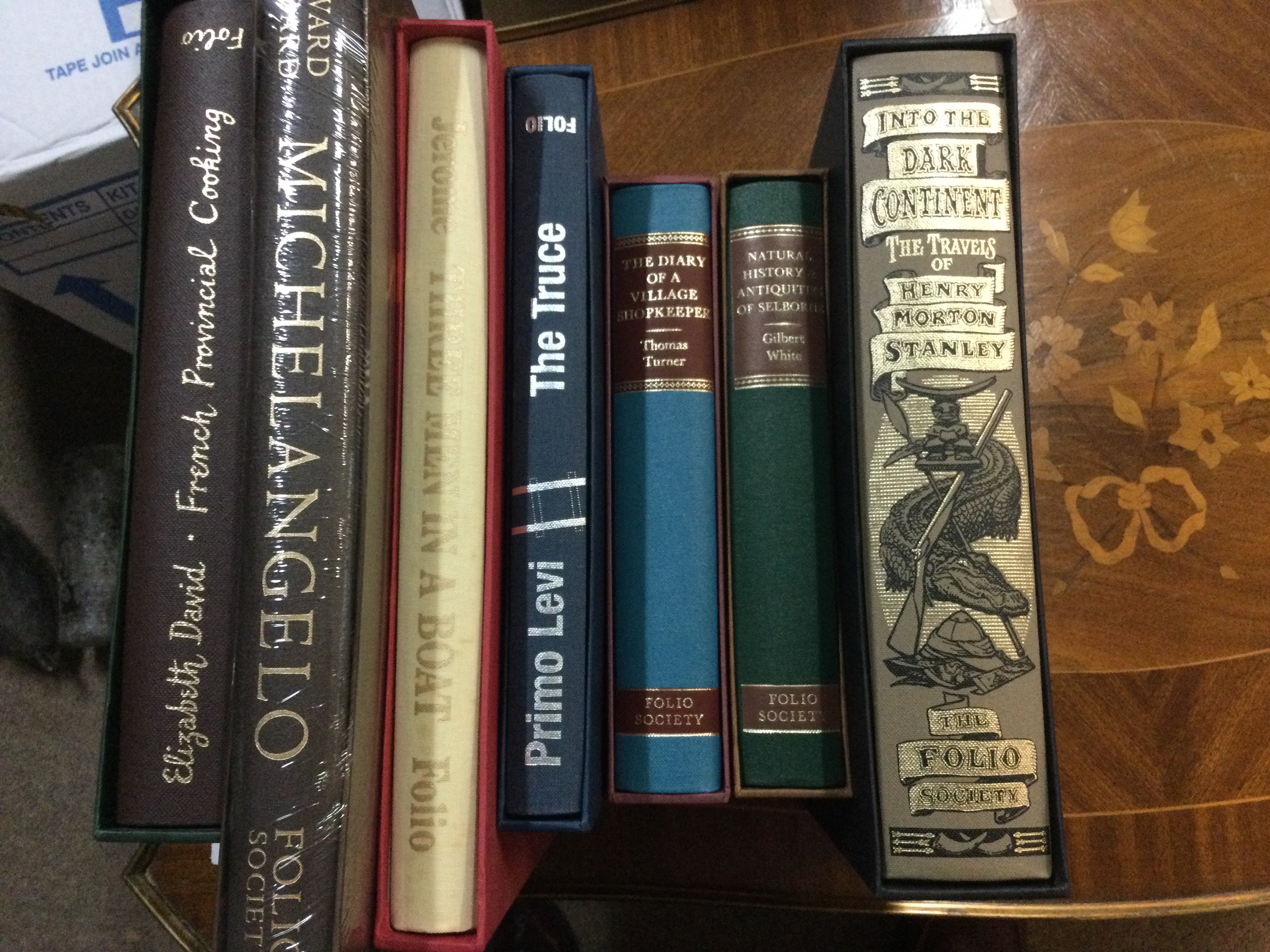 A box containing various books including folio Society .