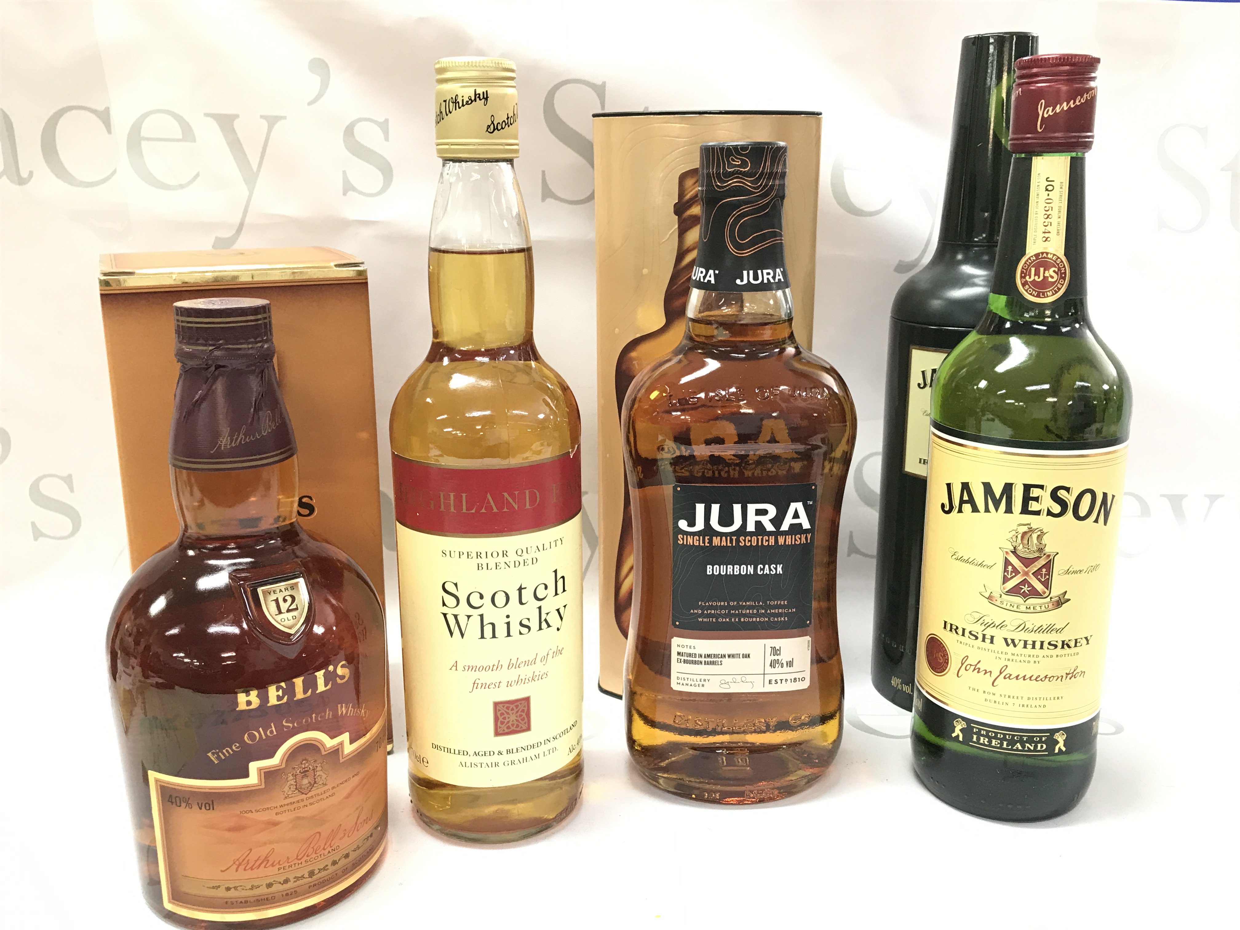 Whiskeys including Highland Earl Scotch Whisky, a boxed bottle of Jura single malt scotch Bourbon cask, Boxed Bells 12 year, Jameson Irish Whisky . This lot cannot be posted