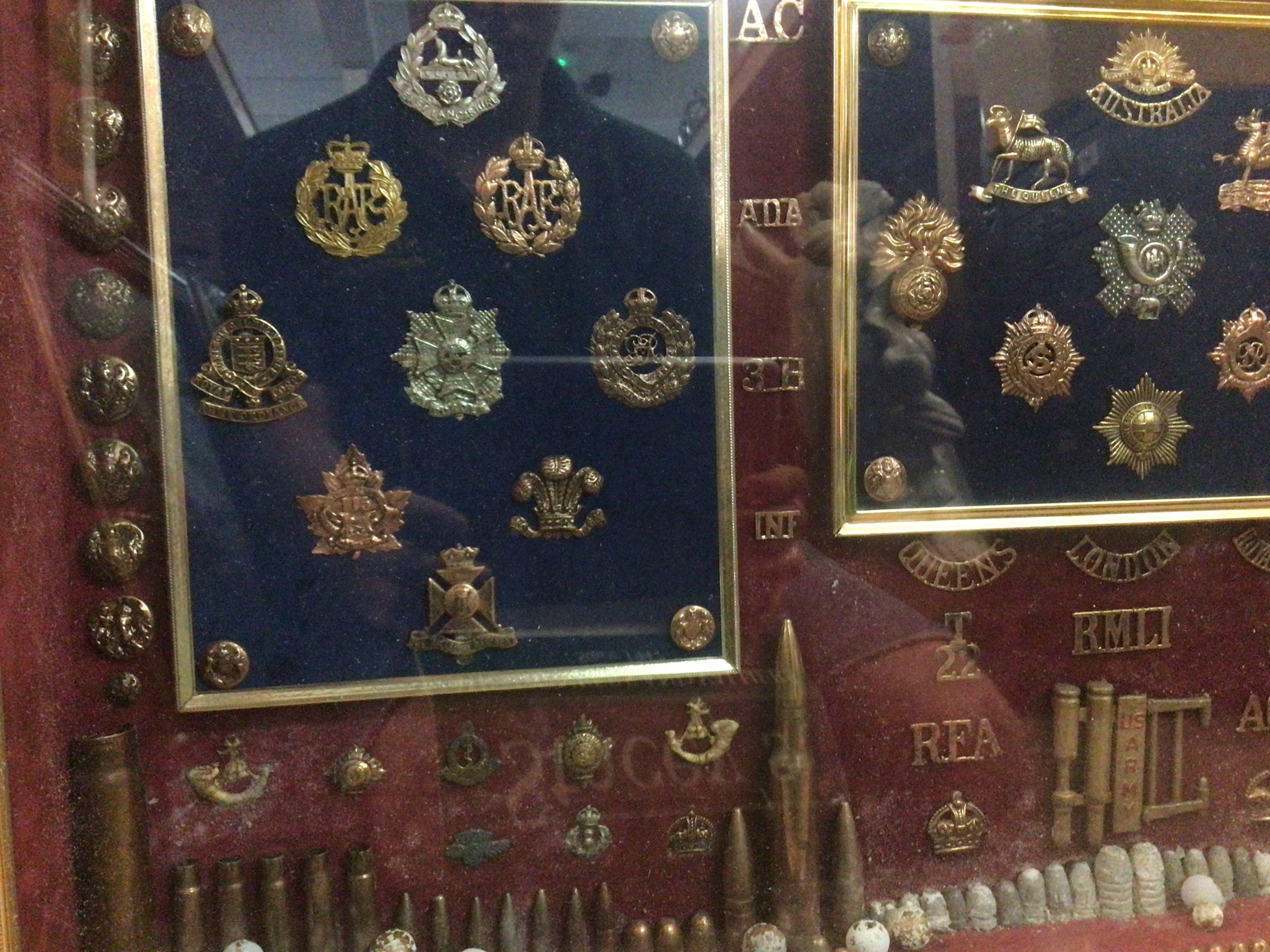 A case containing military badges, buttons , shells including a rare Canadian tank regiment badge. This lot cannot be posted