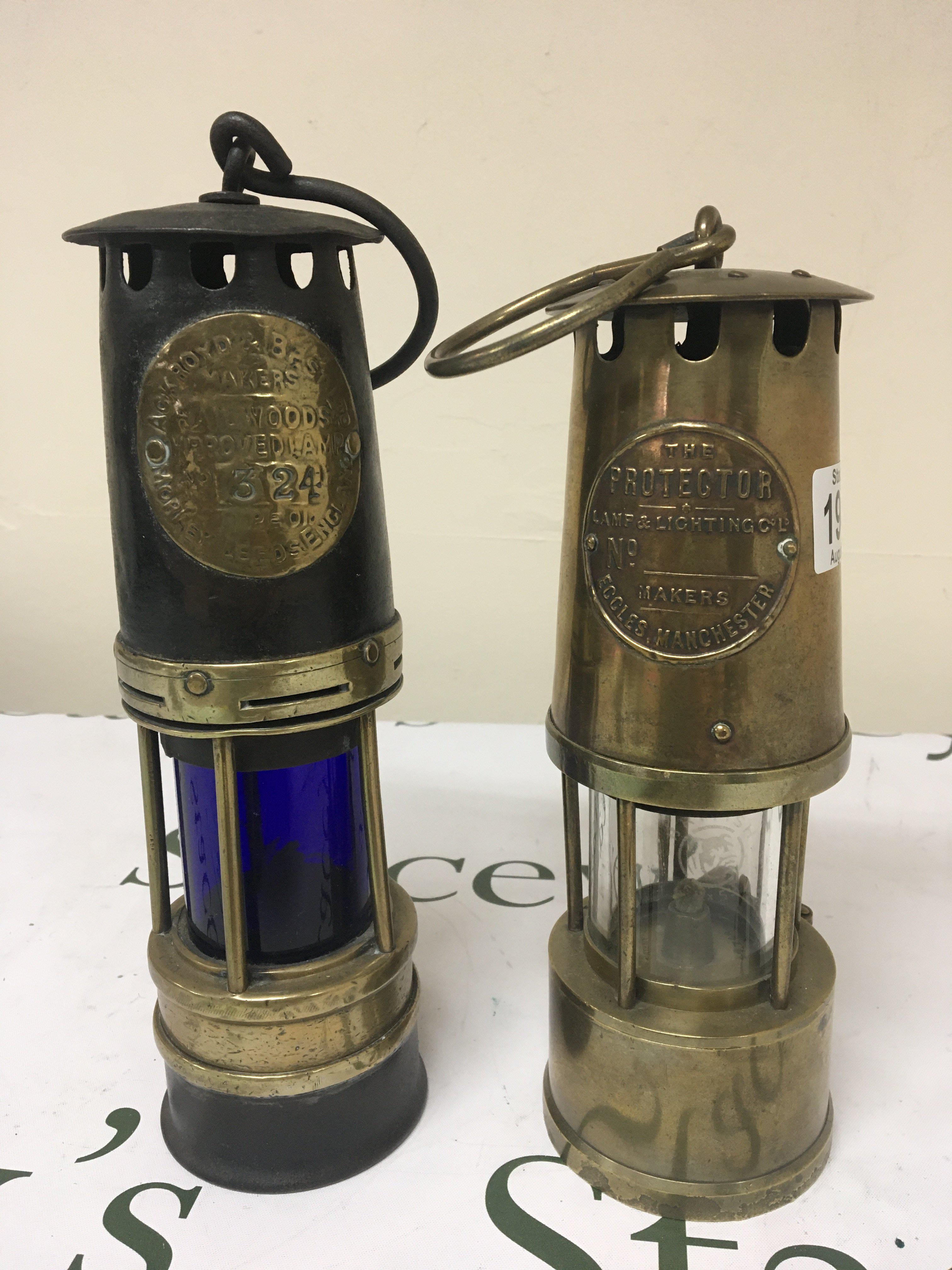 A Bristol Blue glass miners lamp with applied makers label numbered 324 and one other Miners lamp Eccles of Manchester (2)