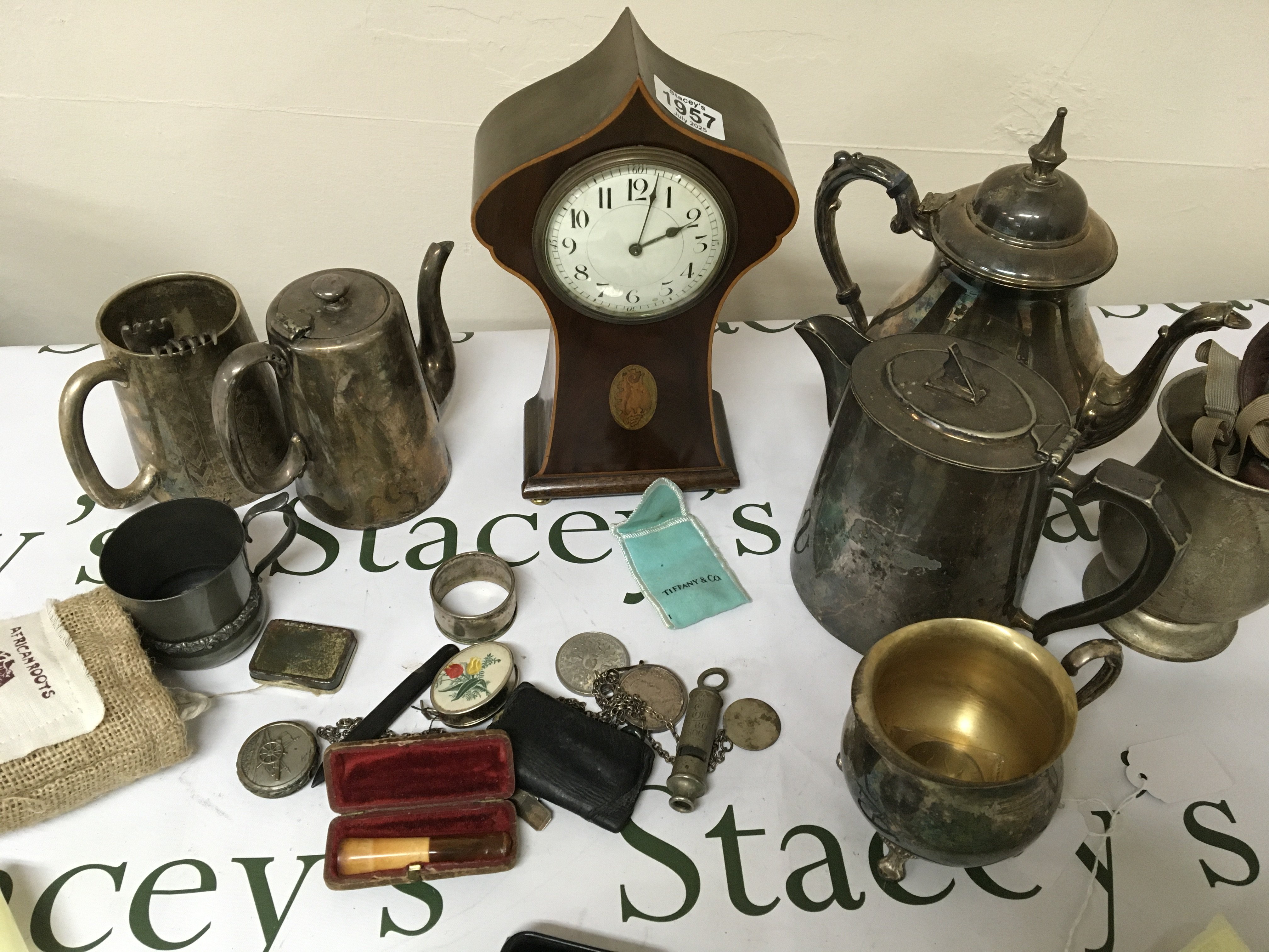 An Edwardian inlaid Mahogany clock a quantity of silver plate silver napkin rings and other oddments.
