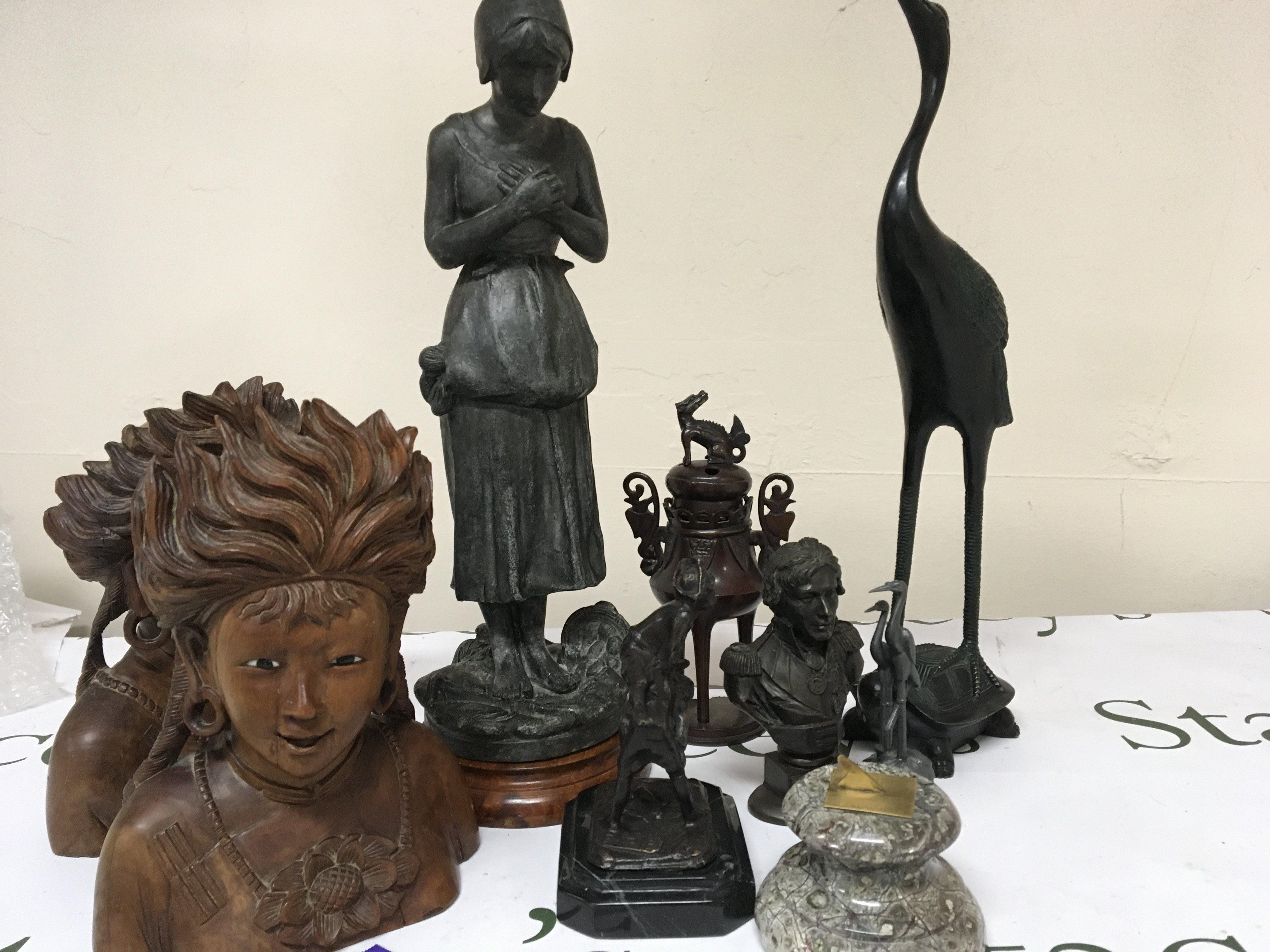 A collection of bronze and metal figures including a Spelter figure reflecting the Irish Potato famine 1845-52. Also Chinese bronze and a pair of carved Malaysian hardwood busts with glass eyes.