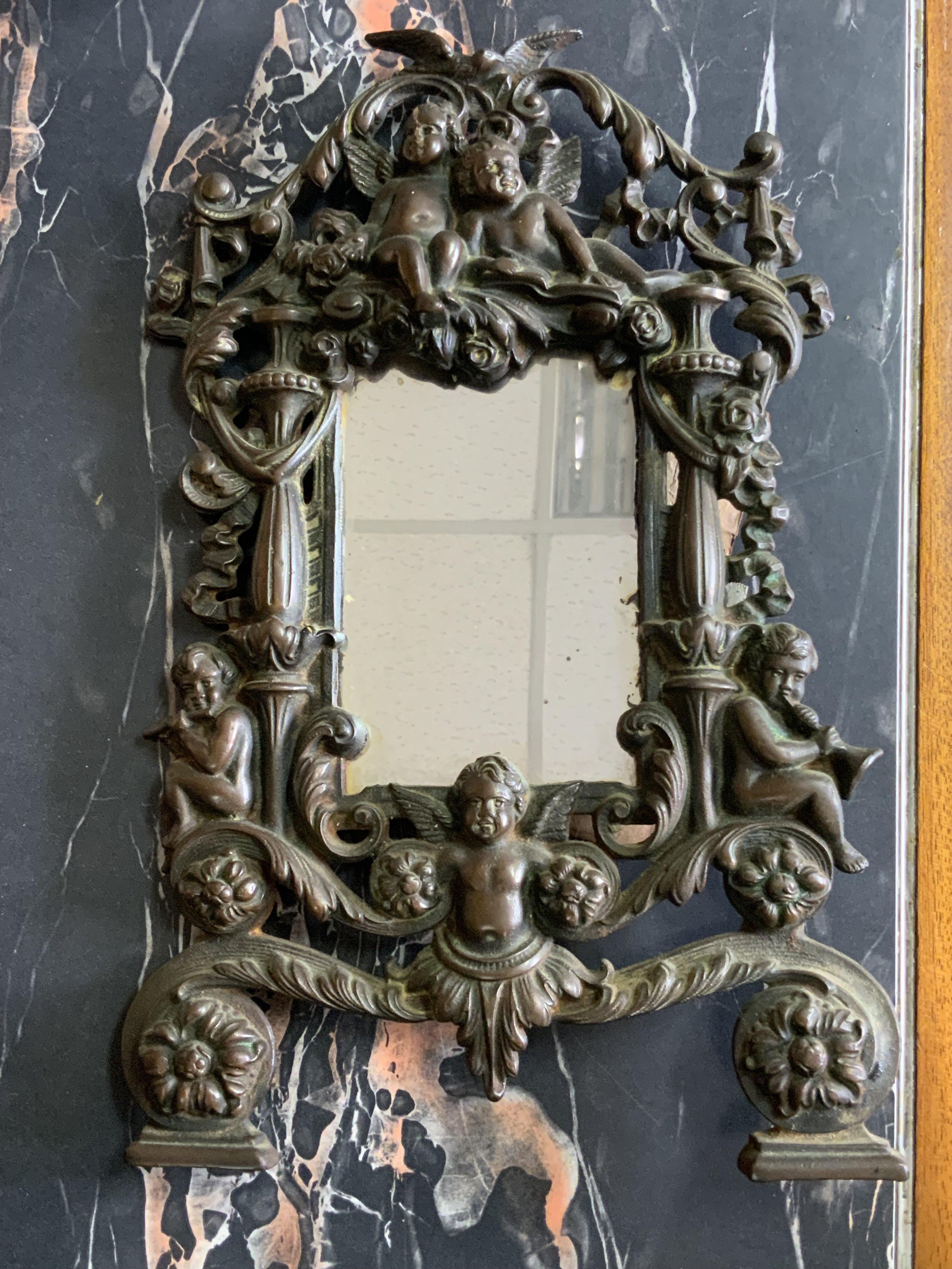 A heavy cast iron mirror/photo frame decorated with putti. 36cm ( stand missing)