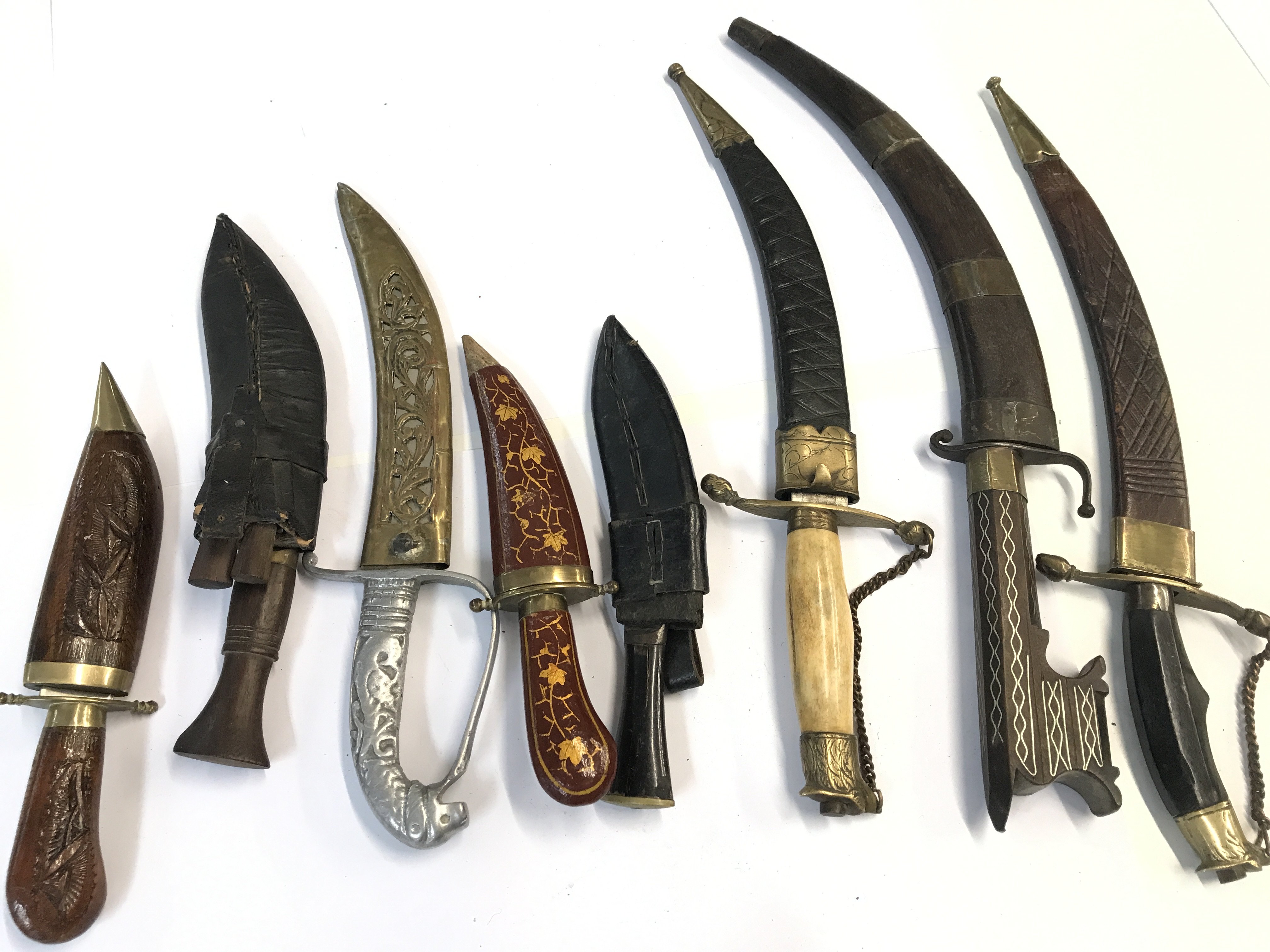 A collection of Middle Eastern and Indian daggers including a Sikh Kirpan dagger small Nepalis kukri knifes and others