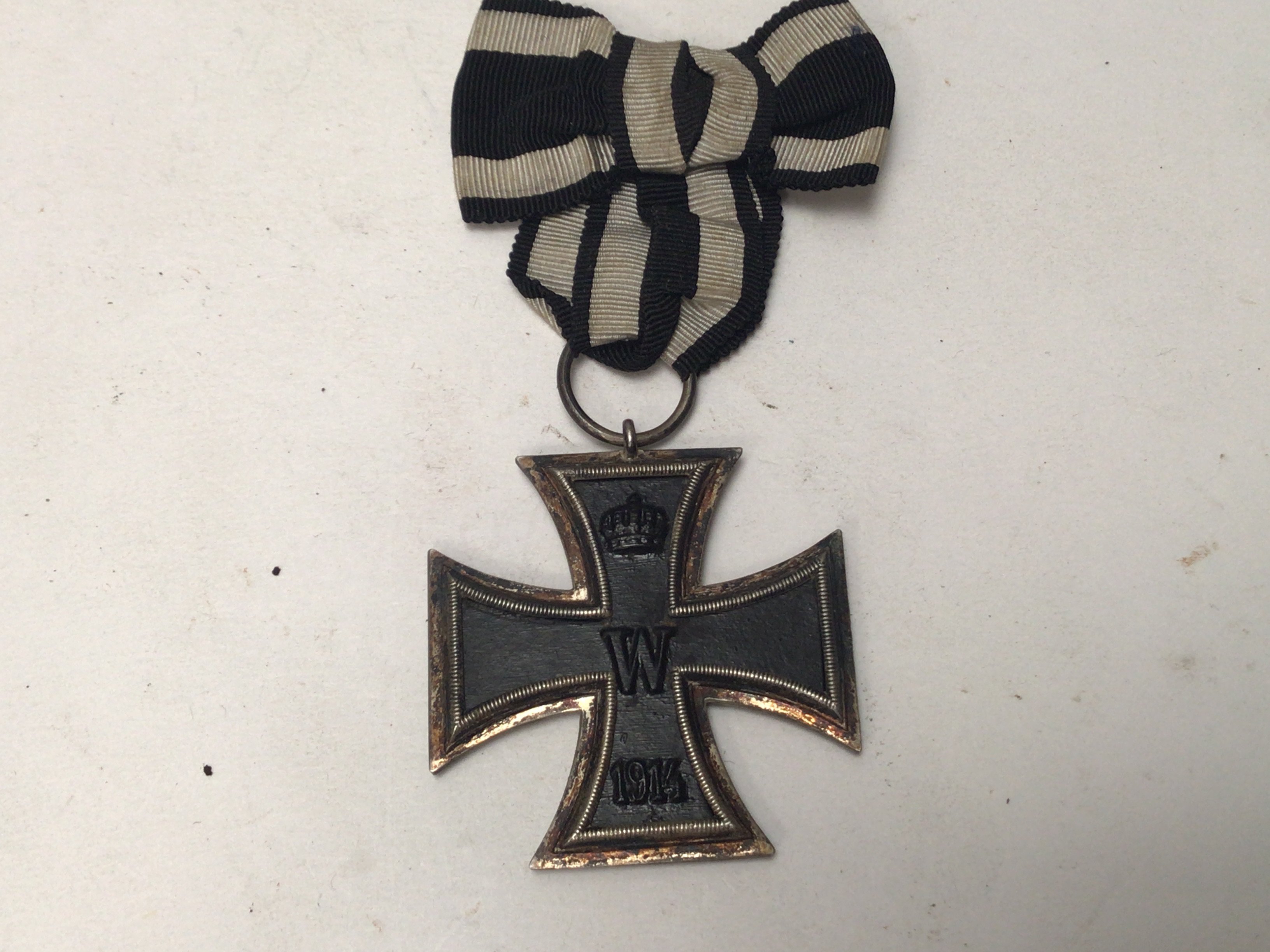 A German Imperial Iron cross with bow tied black and white ribbon.