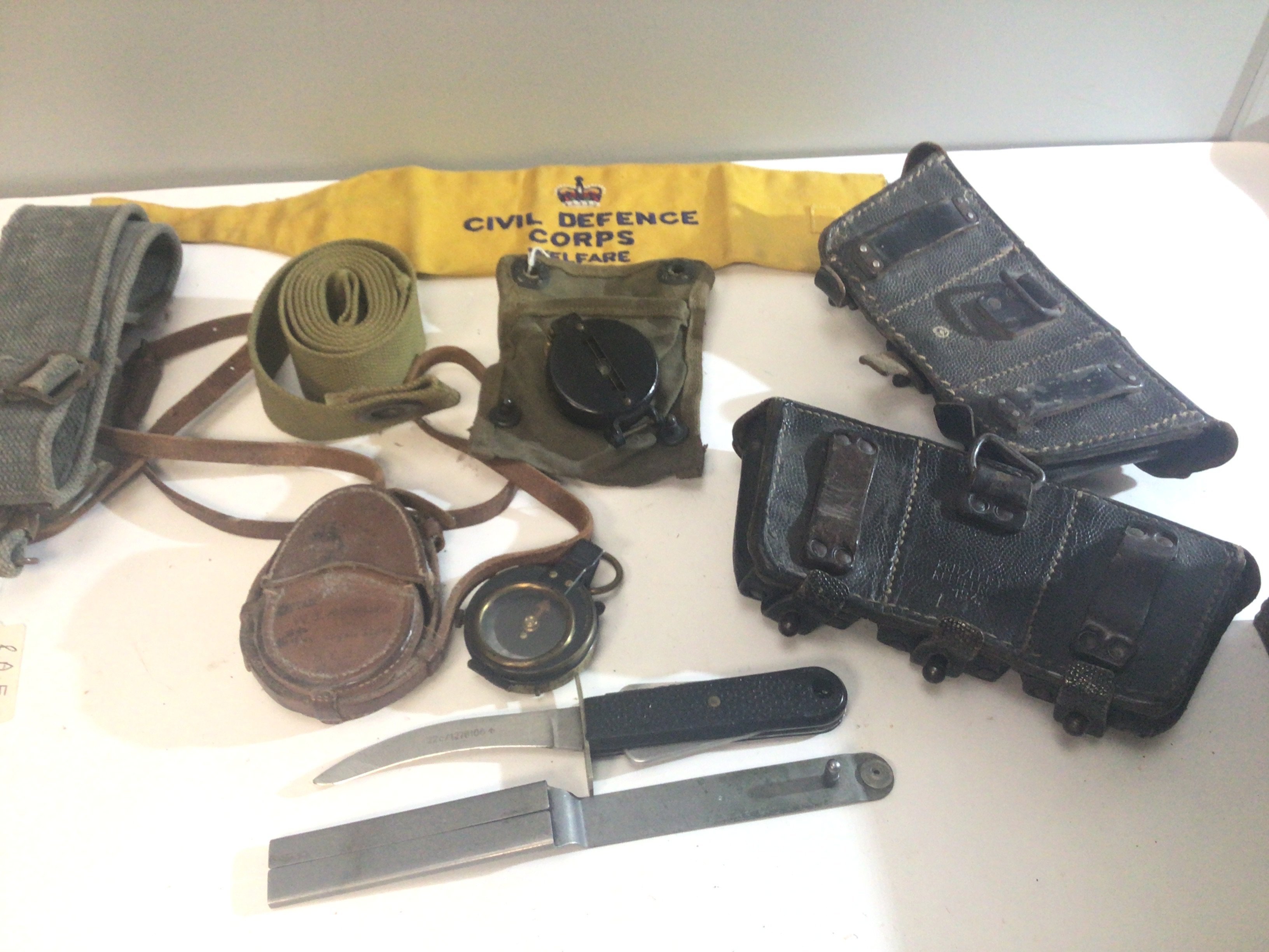 A Military Compass belonging to Captain W J Hepburn The Royal Scots an American II world war compass belts a Sheffield multi purpose knife military issue ammunition pouches and other oddments.