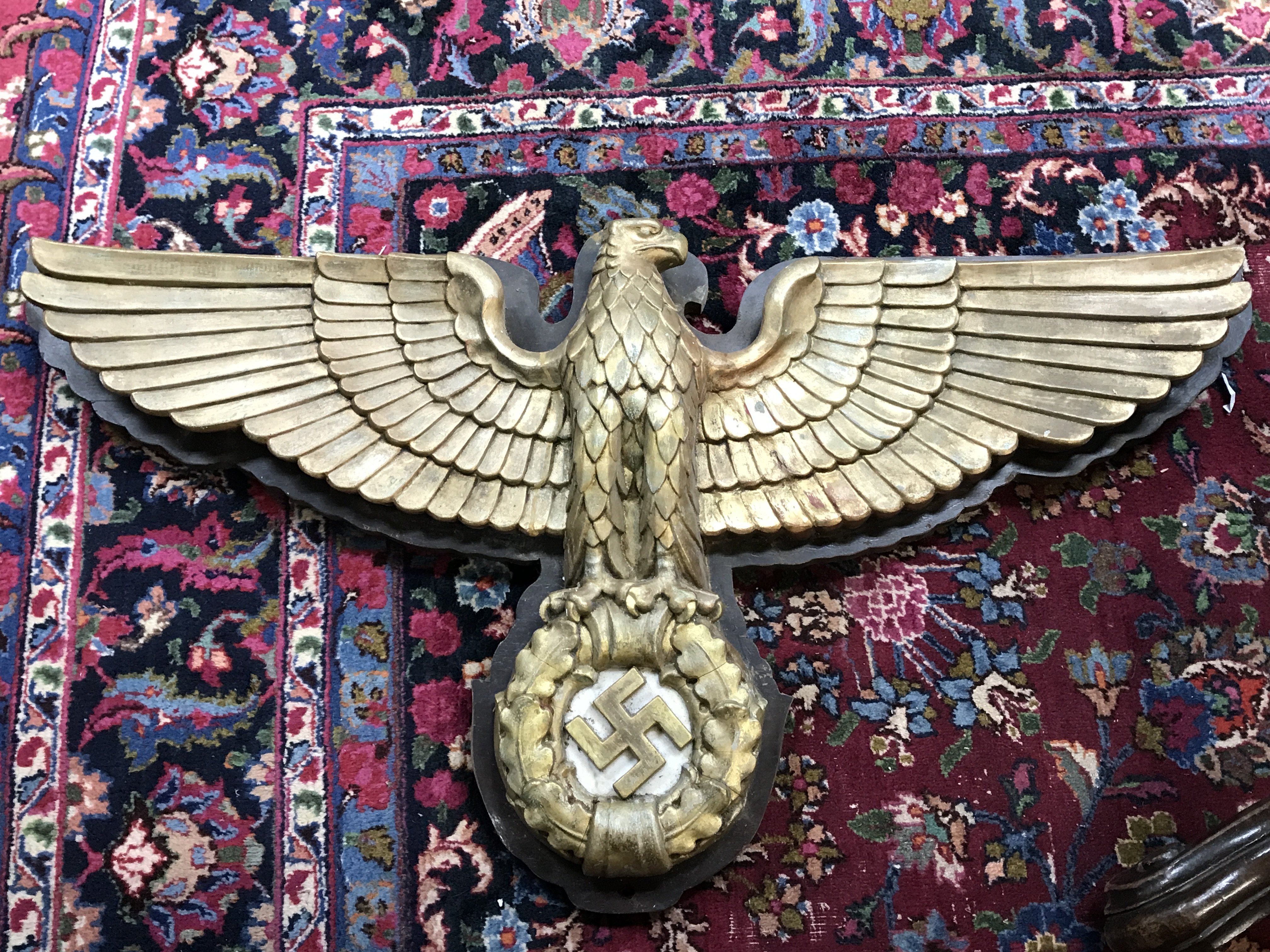 A WW2 Third Reich German eagle wall plaque with a wooden base, marble behind the swastika and the gilt eagle itself composition. 110cm wide 62cm tall approximately .This lot cannot be posted