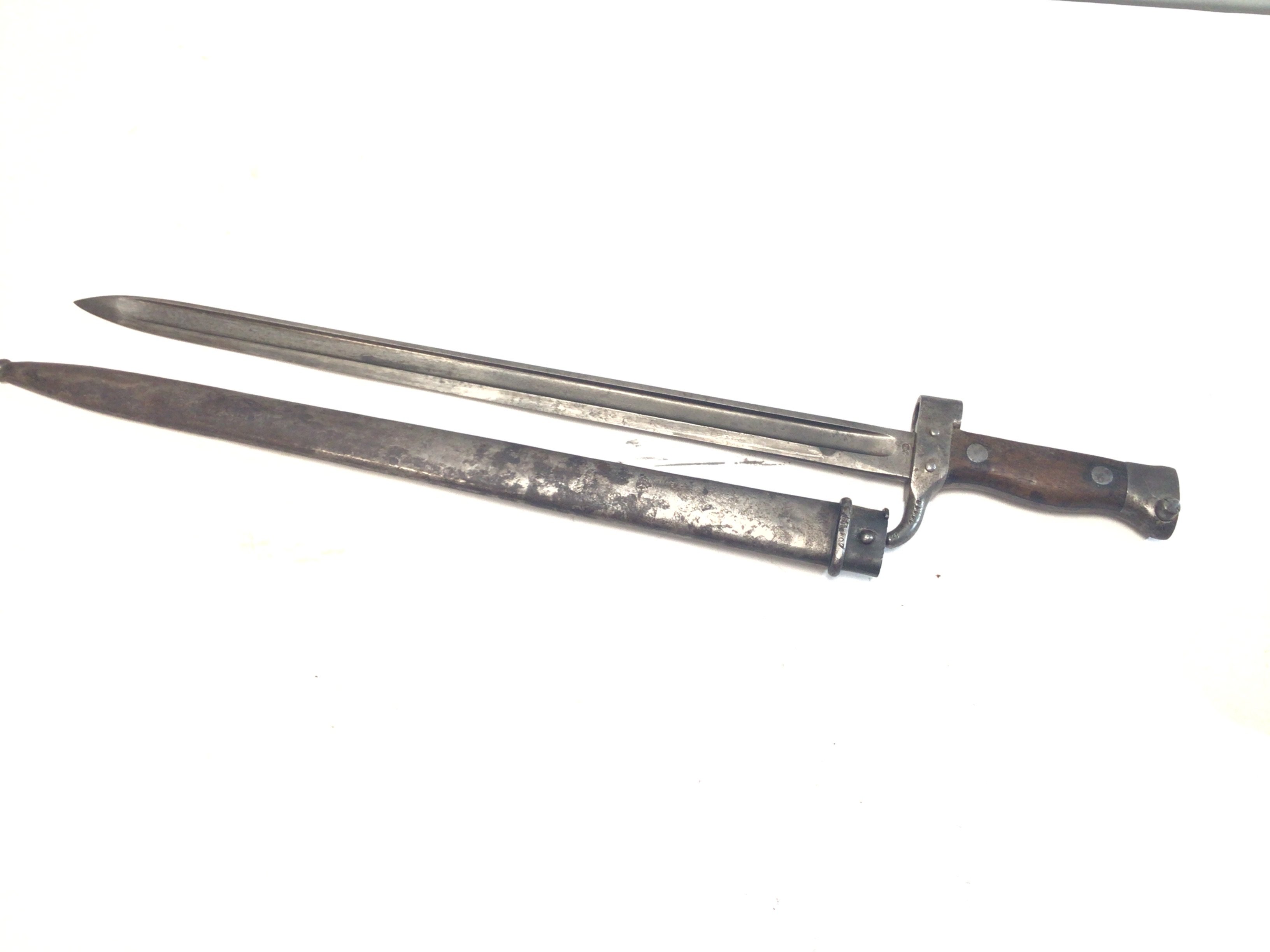 A French 1880 pattern bayonet with a wood grip steel scabbard blade and quilion with stamped marks.
