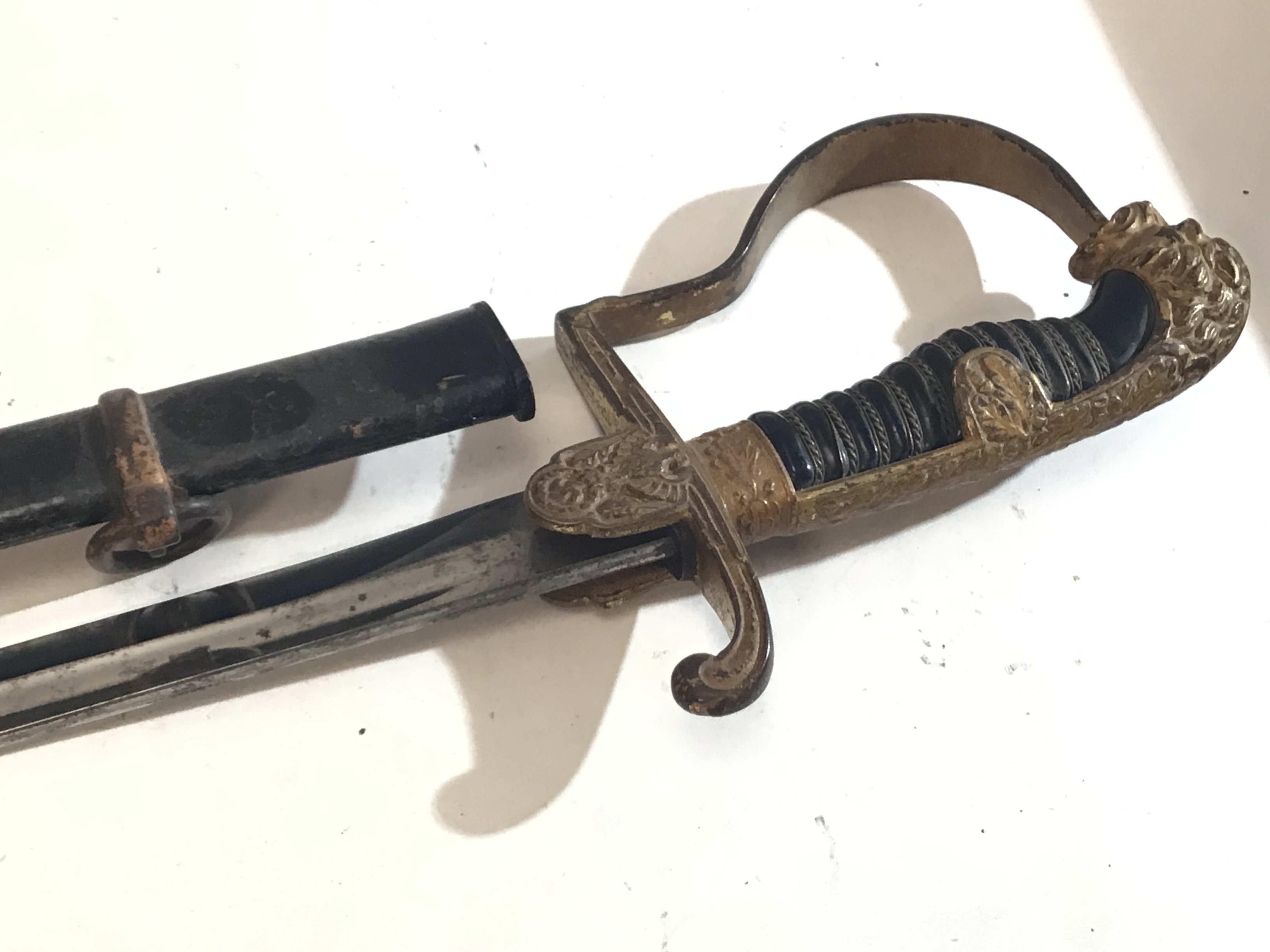 A German Third Reich Military officers dress sword with lion head pommel with red stone eyes with apllied gilt finish the steel blade with maker stamp a nice example with wear in keeping with age.